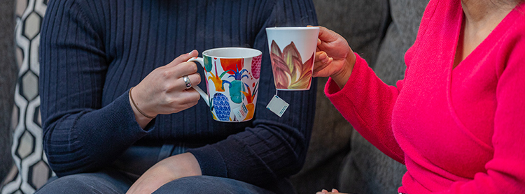 Women's hands holding mugs