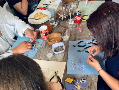 People at a table making jewellery