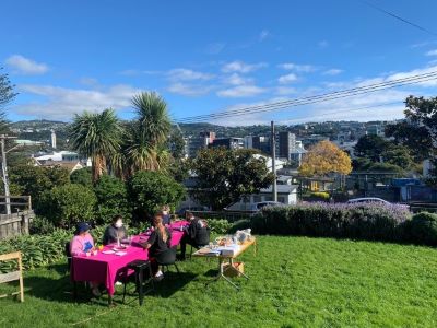 A group of people painting on pottery in the sunshine